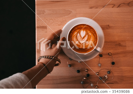 Woman hand holding cup of cappuccino coffee 35439086