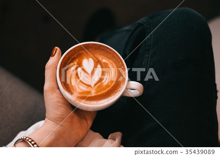 Woman hand holding cup of cappuccino coffee 35439089
