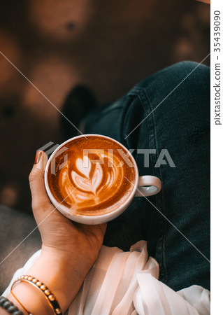 Woman hand holding cup of cappuccino coffee 35439090