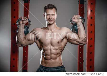 Handsome young man working out in gym kettlebell.. 35443235