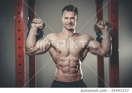Handsome young man working out in gym kettlebell.. 35443237