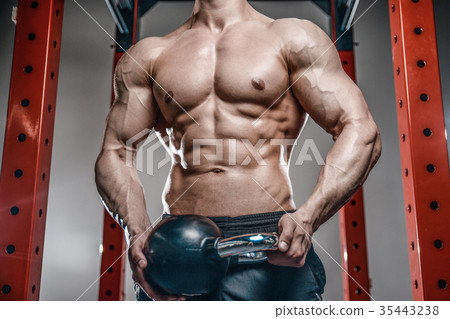 Handsome young man working out in gym kettlebell.. 35443238