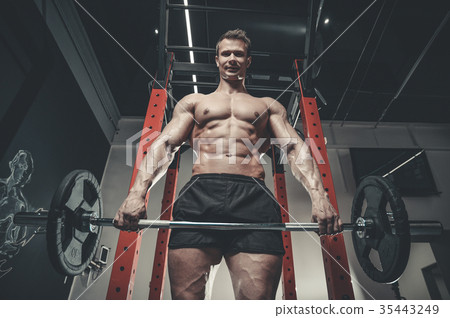 Handsome model young man training abs in gym 35443249