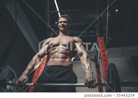 Handsome model young man training abs in gym 35443254