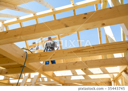 Builders at work with wooden roof construction. Builders at work with wooden roof construction. 35443745