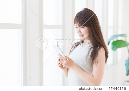 觀看智能手機的婦女 觀看智能手機的婦女 35449156