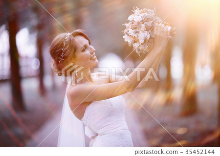 Bride with a bouquet of flowers in a white dress at a wedding 35452144