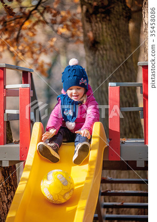 Happy three-year baby girl in jacket on slide 35458086