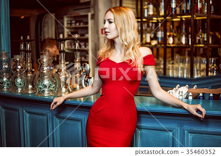 Gorgeous blond woman in fashion red dress staying at the bar 35460352