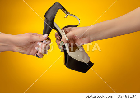 Brown woman shoe with female and male on hands Brown woman shoe with female and male on hands 35463134