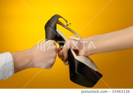 Brown woman shoe with female and male on hands Brown woman shoe with female and male on hands 35463136