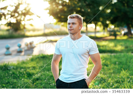 Man trainer in headphones. In a white T-shirt 35463339