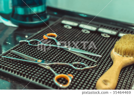 Hairdresser makes hairstyle a man with a beard 35464469