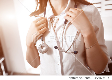 A young female doctor in a white smock holding a 35469603
