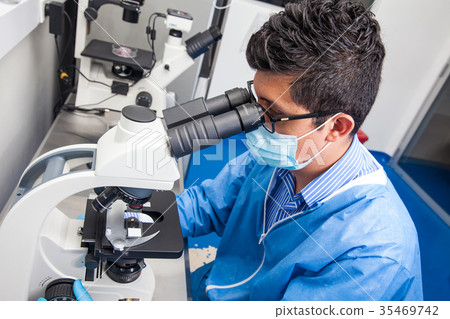 ale scientist looking at slides under microscope ale scientist looking at slides under microscope 35469742