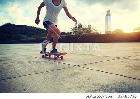 Woman practicing with skateboard at sunrise city 35469756