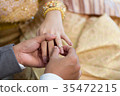 Bride hand and groom hand are wearing a ring. 35472215