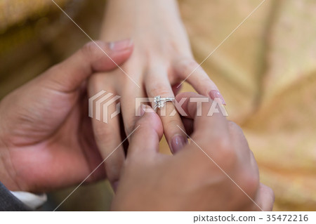 Bride hand and groom hand are wearing a ring. 35472216