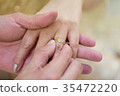 Bride hand and groom hand are wearing a ring. 35472220