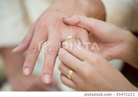 Bride hand and groom hand are wearing a ring. Bride hand and groom hand are wearing a ring. 35472221