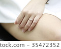 Woman hand with diamond ring and watch on her leg. 35472352