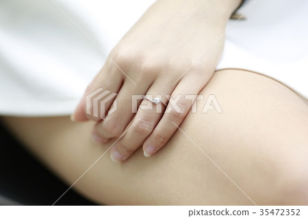 Woman hand with diamond ring and watch on her leg. Woman hand with diamond ring and watch on her leg. 35472352