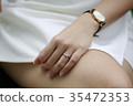 Woman hand with diamond ring and watch on her leg. 35472353