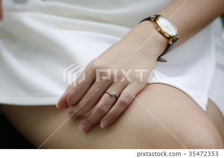 Woman hand with diamond ring and watch on her leg. Woman hand with diamond ring and watch on her leg. 35472353
