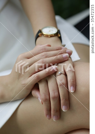 Woman hand with diamond ring and watch on her leg. Woman hand with diamond ring and watch on her leg. 35472355