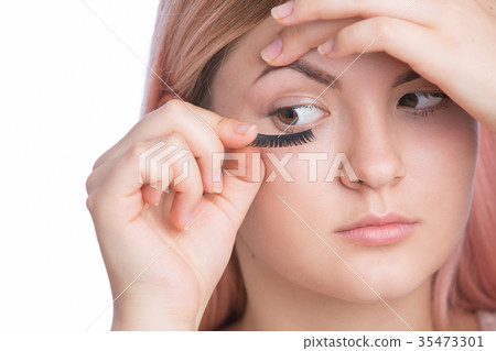 applying false eyelashes