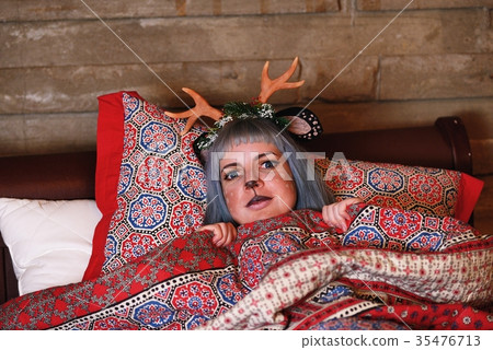 Beautiful girl in a Christmas deer costume lie in bed 35476713