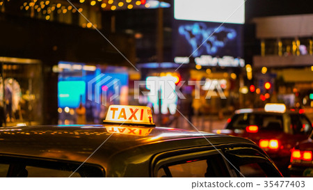 Taxi sign night blur view in nightlife area Taxi sign night blur view in nightlife area 35477403