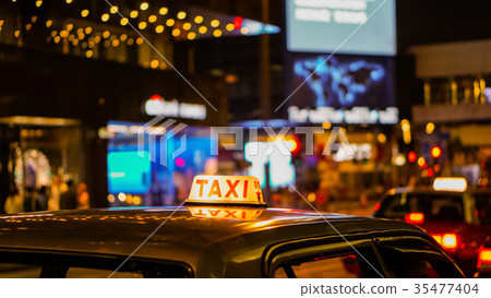 Taxi sign night blur view in nightlife area Taxi sign night blur view in nightlife area 35477404