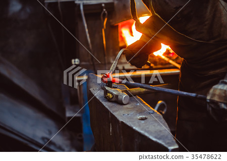 blacksmith working on an anvil blacksmith working on an anvil 35478622