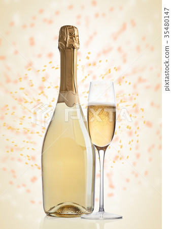 Bottle and glass of yellow champagne on yellow Bottle and glass of yellow champagne on yellow 35480147