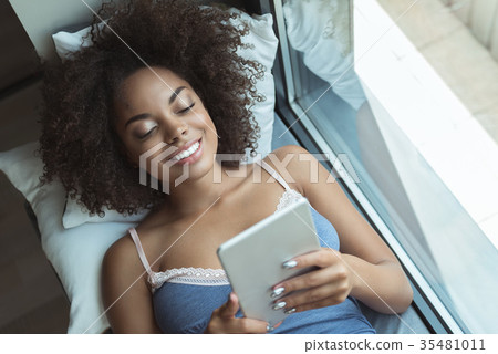 Beaming female watching at digital device 35481011