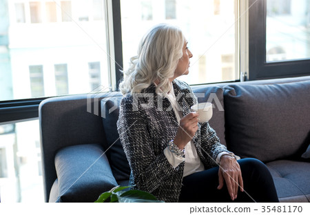 Attractive gray-haired lady is drinking beverage Attractive gray-haired lady is drinking beverage 35481170
