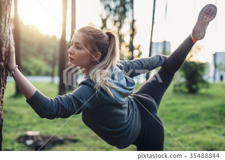 Female athlete doing leg hold pose stretching 35488844