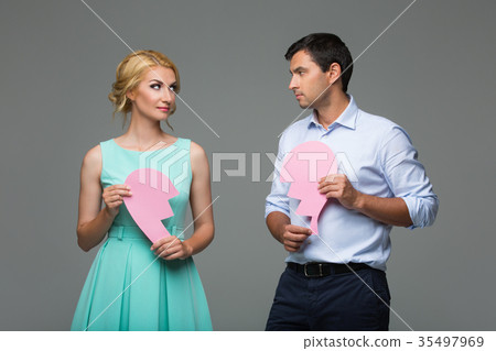 Beautiful couple holding pink broken heart Beautiful couple holding pink broken heart 35497969