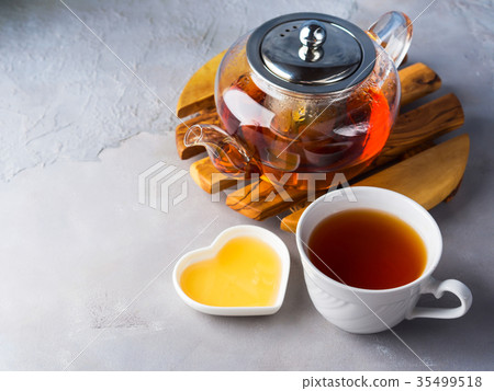 Teapot of red tea and honey 35499518