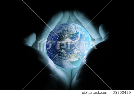 Men's hands holding the planet earth with a blue glow on a black background. 35500459