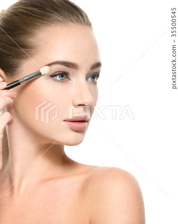 Girl makes makeup. Woman applies makeup shadow on the eyelid 35500545