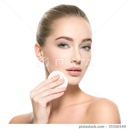 Girl removes makeup cotton ball from face Girl removes makeup cotton ball from face 35500549