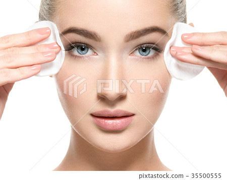 Girl removes makeup cotton ball from face Girl removes makeup cotton ball from face 35500555