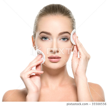 Girl removes makeup cotton ball from face Girl removes makeup cotton ball from face 35500556