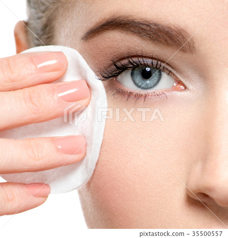 Girl removes makeup cotton ball from face 35500557