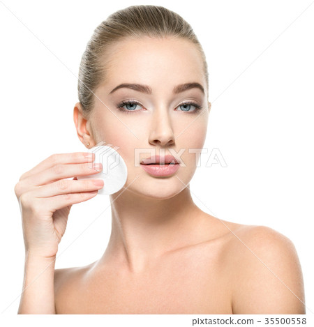 Girl removes makeup cotton ball from face 35500558