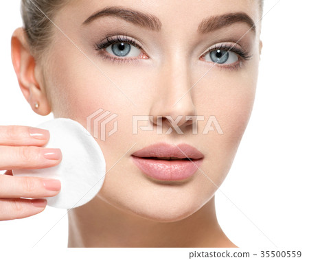 Girl removes makeup cotton ball from face Girl removes makeup cotton ball from face 35500559