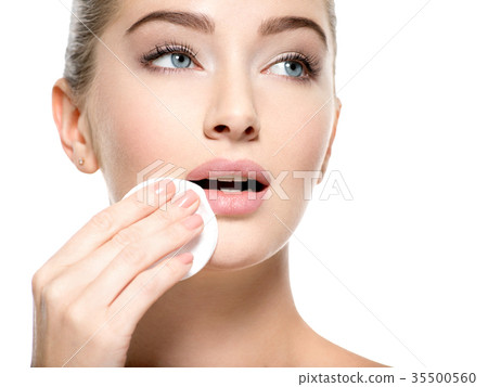 Girl removes makeup cotton ball from face Girl removes makeup cotton ball from face 35500560