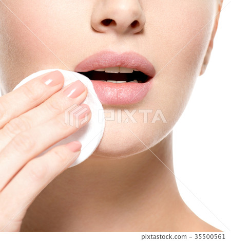 Girl removes makeup cotton ball from face Girl removes makeup cotton ball from face 35500561